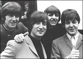 The other Beatles with John Lennon the day he finally passed his driver's test. Pictured left to right: George Harrison, John Lennon, Ringo Starr, and Paul McCartney.