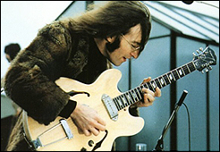 John Lennon plays his guitar during the Beatles' historic rooftop concert on January 30, 1969.