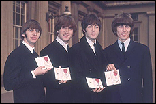 The Beatles receive their MBEs from Queen Elizabeth.