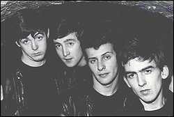 The Beatles pose for a photo at The Cavern Club in 1961. Left to right: Paul McCartney, John Lennon, Pete Best, and George Harrison.