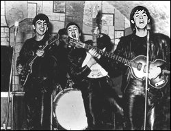 The Beatles having fun on stage at The Cavern Club in Liverpool, England. From left to right: George Harrison, John Lennon, and Paul McCartney.