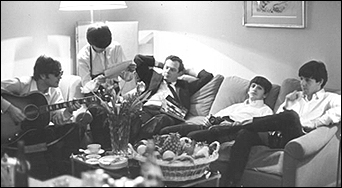 The Beatles relax in their hotel room at the George V in Paris, France, circa January 1964. Left to right: John Lennon, George Harrison, Brian Epstein, Ringo Starr and Paul McCartney.