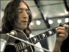 John Lennon plays guitar during the recording of the Beatles' Let It Be album.