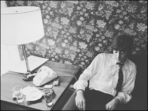 John Lennon looks stressed out and forlorn in his Chicago hotel room, waiting to go to the Beatles press conference where he will be forced to apologize for his statement about The Beatles being more popular than Christ.
